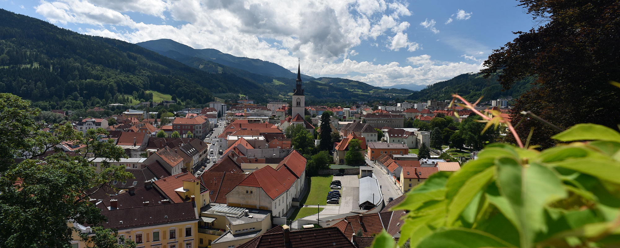 Blick vom Schlossberg auf die Stadt Bruck an der Mur - zu sehen ist die Stadtpfarrkirche und Häuserdächer.